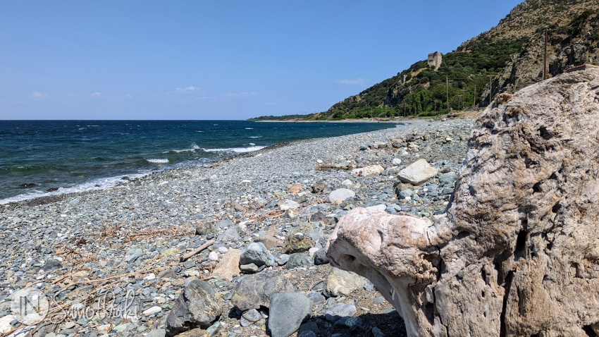 The pebbly beach and the neighboring medieval towers