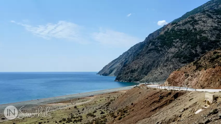 Kipos Beach streches to the left of the winding road.