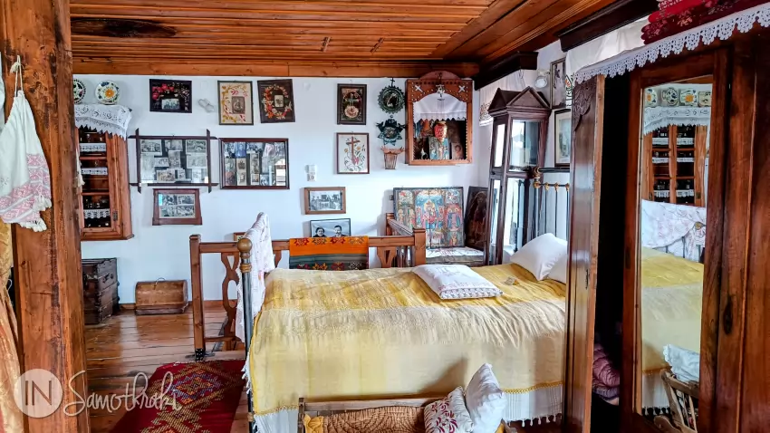 The iron bed is covered by a silk coverlet.
