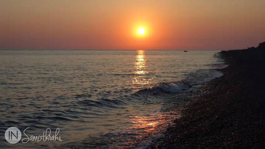 The sunset turns the sea bright orange.