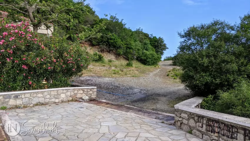 The dirt road to the right of the building, that goes up on the Psarotherma hill.