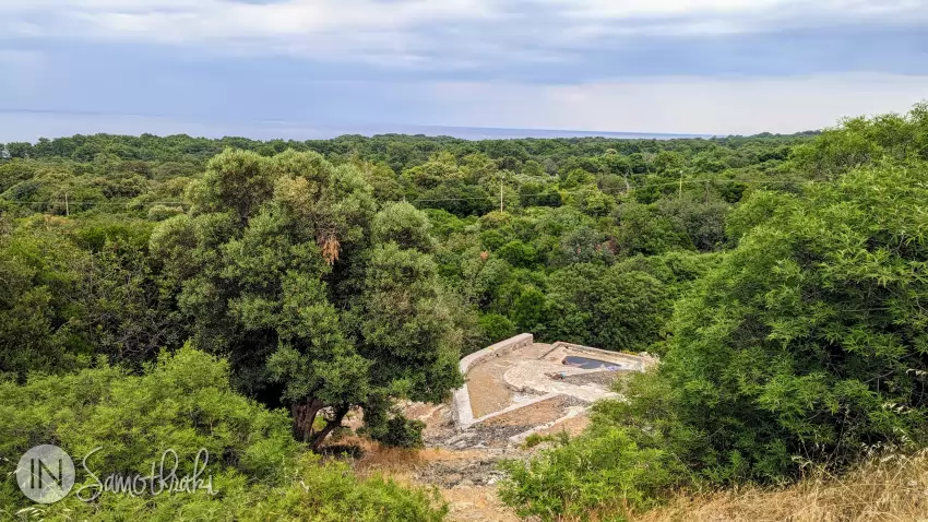 The first thermal water pool is further down the road, surrounded by vegetation.